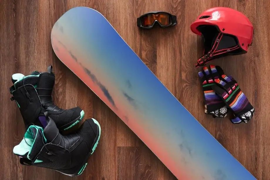 A snowboarder's kit with board, bindings, and helmet.