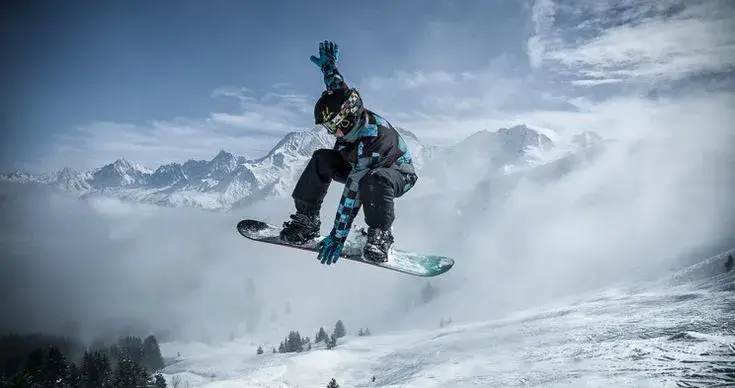 A snowboard showing its rocker profile against a flat surface.