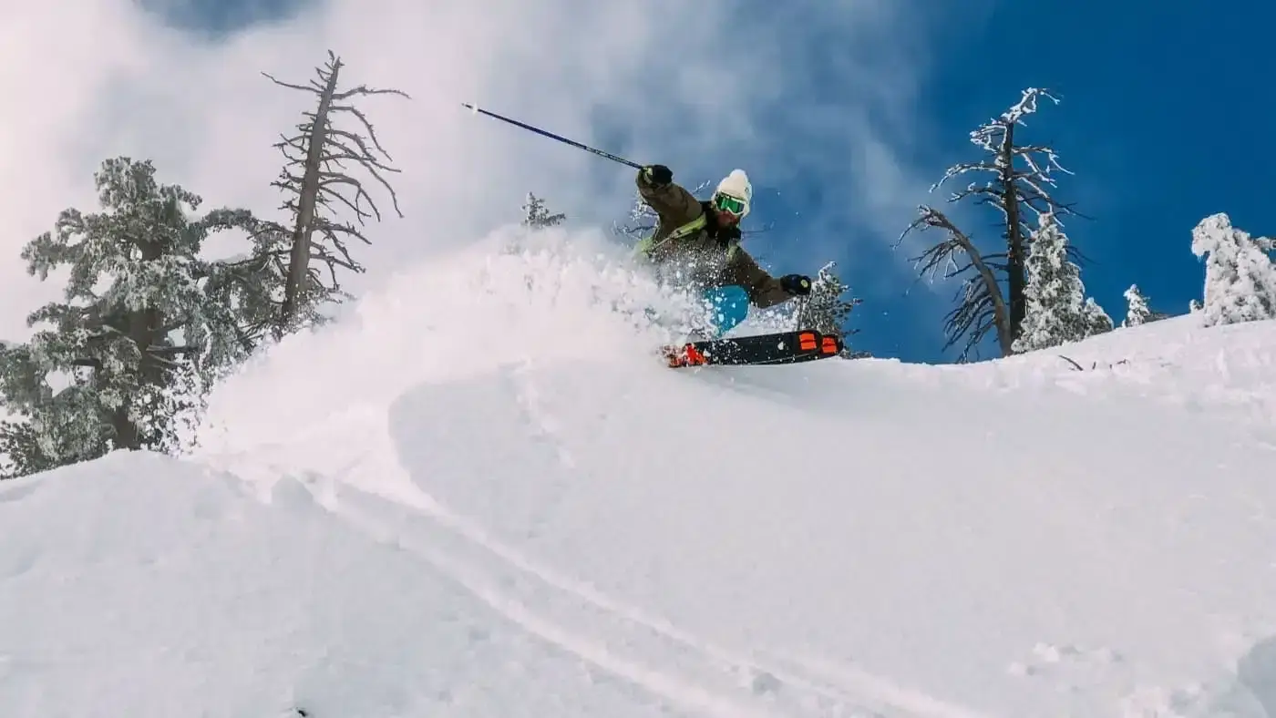 Skier carving through deep powder snow.