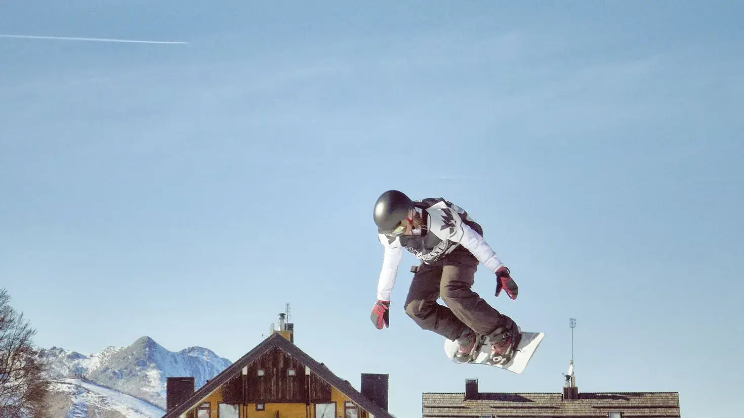 Snowboarder executing a grab trick in mid-air.
