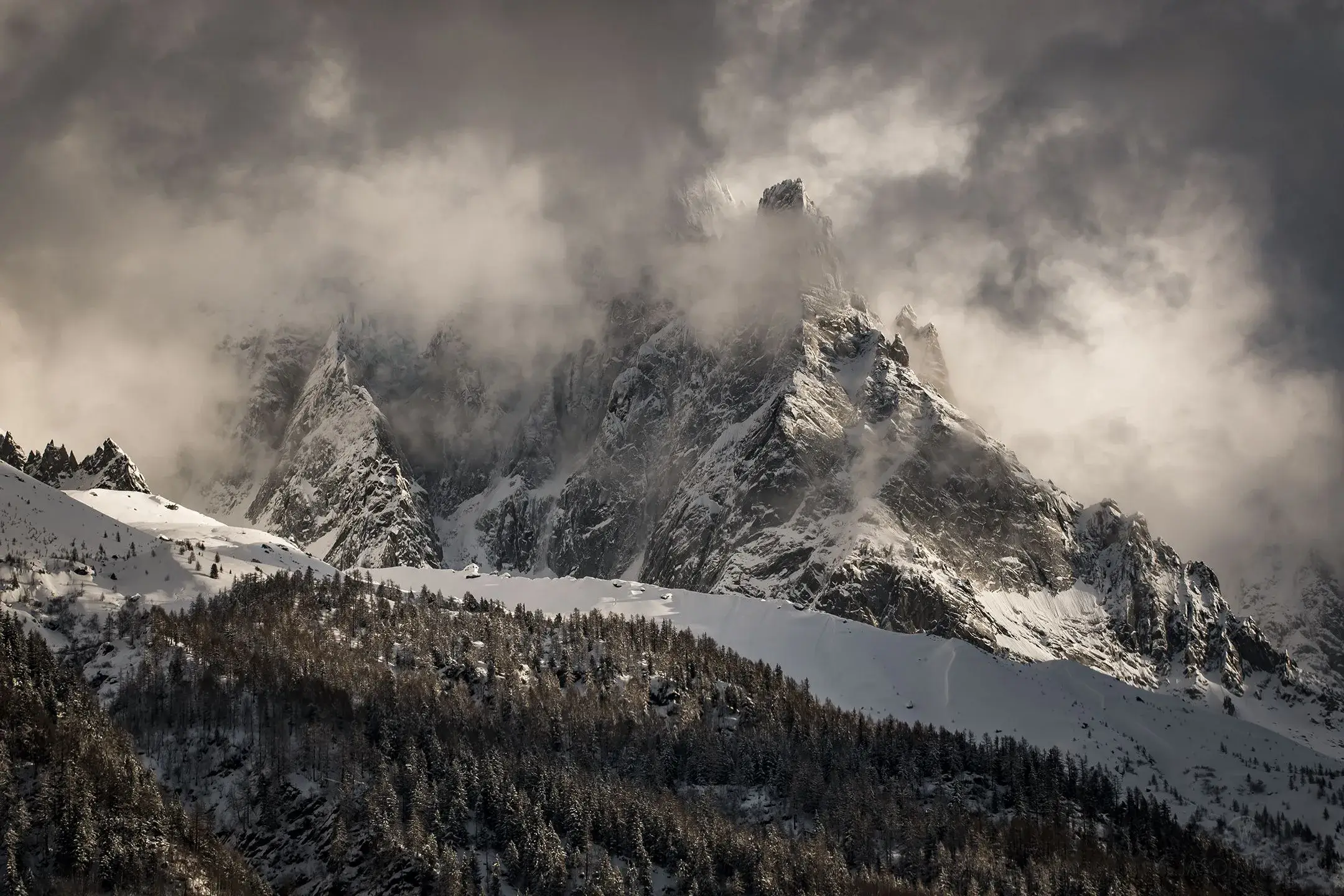 Dramatic clouds over a snowy peak.