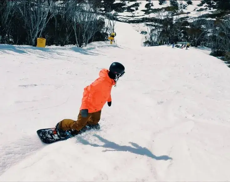 A snowboarder on a box feature.